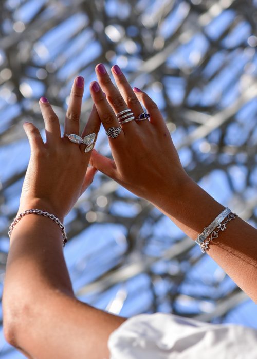Photo of jewellery shot at Kew Gardens featuring silver rings in hand against the blue sky
